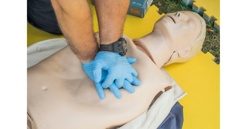 Nahaufnahme von Händen, die HLW an einer Puppe für Erste-Hilfe-Training durchführen.